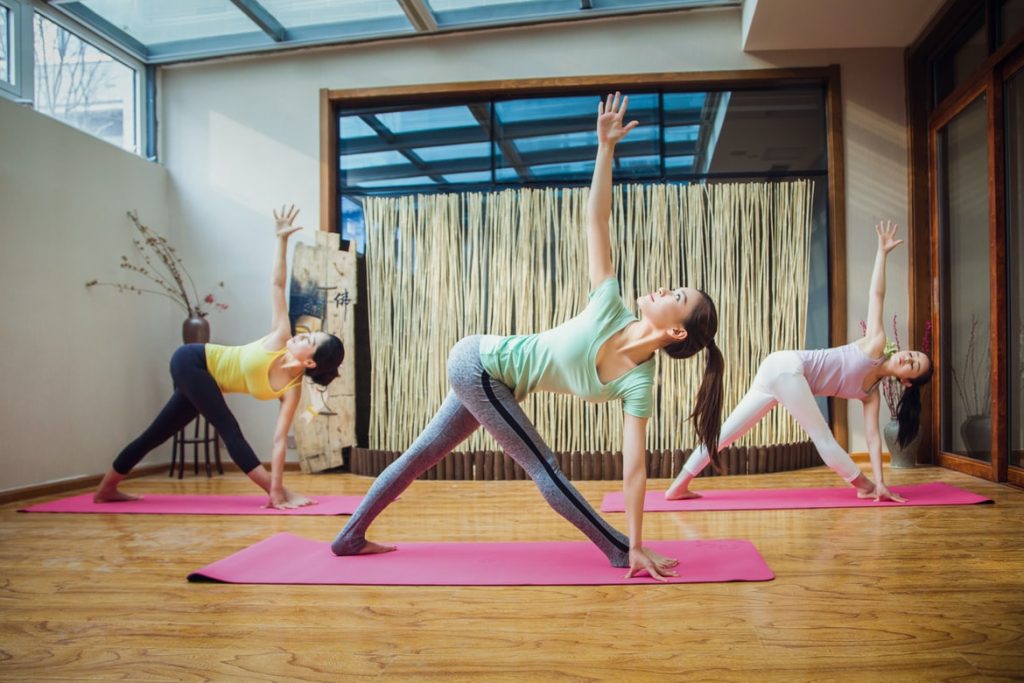 three women doing yoga poses